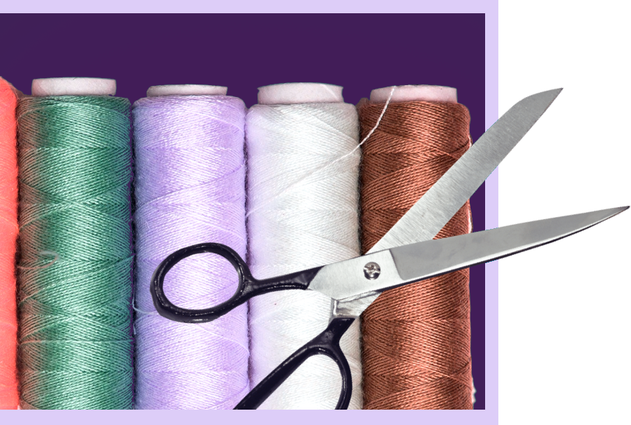 A pair of scissors overlaid on top of spools of thread in different colours.